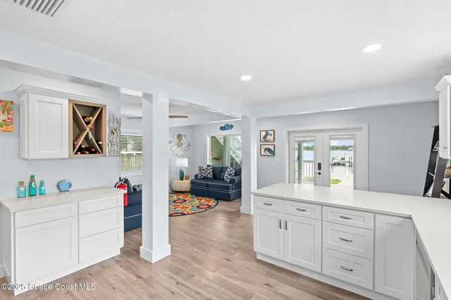 a hallway with white cabinets and wooden floor