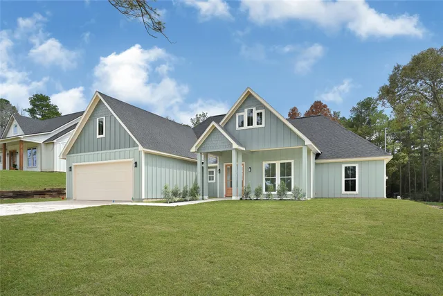 a front view of a house with a garden and yard