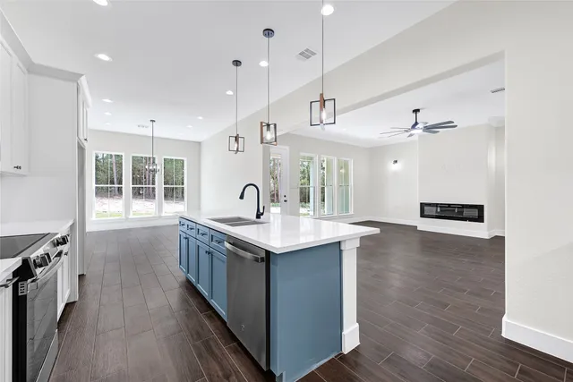 a kitchen with stainless steel appliances granite countertop a sink stove and wooden floor
