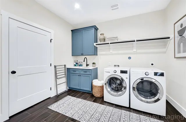 a utility room with sink dryer and washer