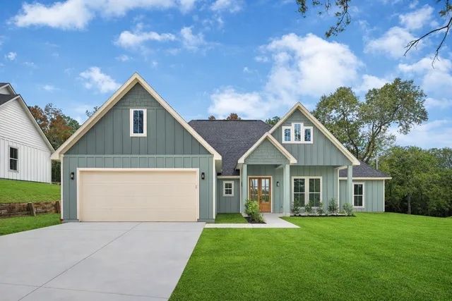 a front view of a house with a garden and yard