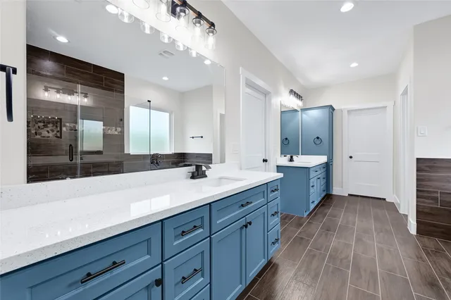 a spacious bathroom with a granite countertop sink mirror and shower