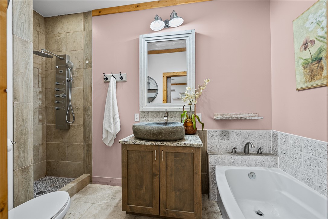 183 Little Eastatoee Road Sunset, SC 29685 - Photo 41 of 50 A well-appointed bathroom features a natural stone vessel sink and a tiled shower with a multi-function shower system.