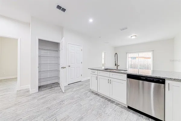 a kitchen with granite countertop white cabinets and appliances