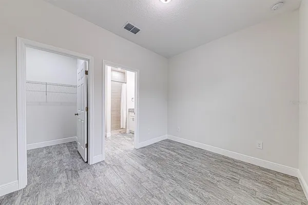 an empty room with wooden floor & closet area