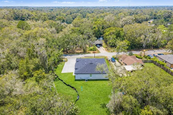 a aerial view of a house with a yard balcony and mountain view in back