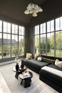 a living room with furniture and a large window with garden view