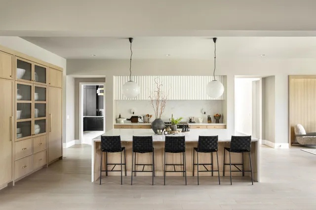 a view of a dining room and livingroom with furniture a rug a fireplace and wooden floors