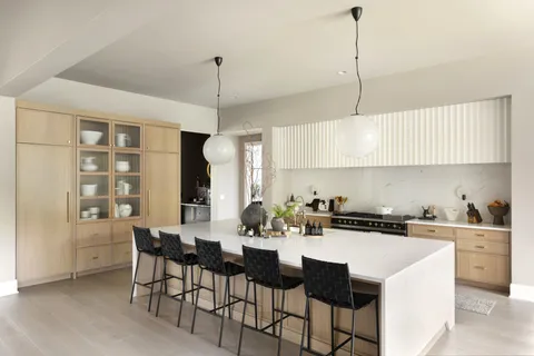 a kitchen with a dining table chairs and white cabinets