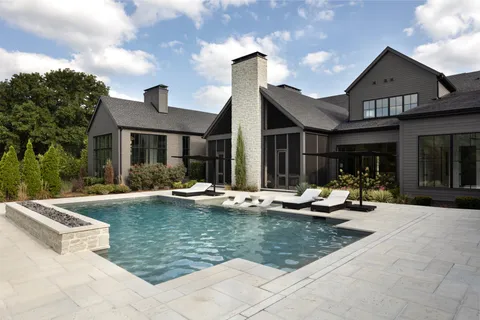 a patio with a table and chairs and potted plants