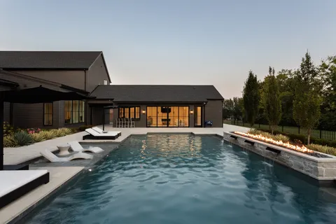 a view of a house with swimming pool and sitting area