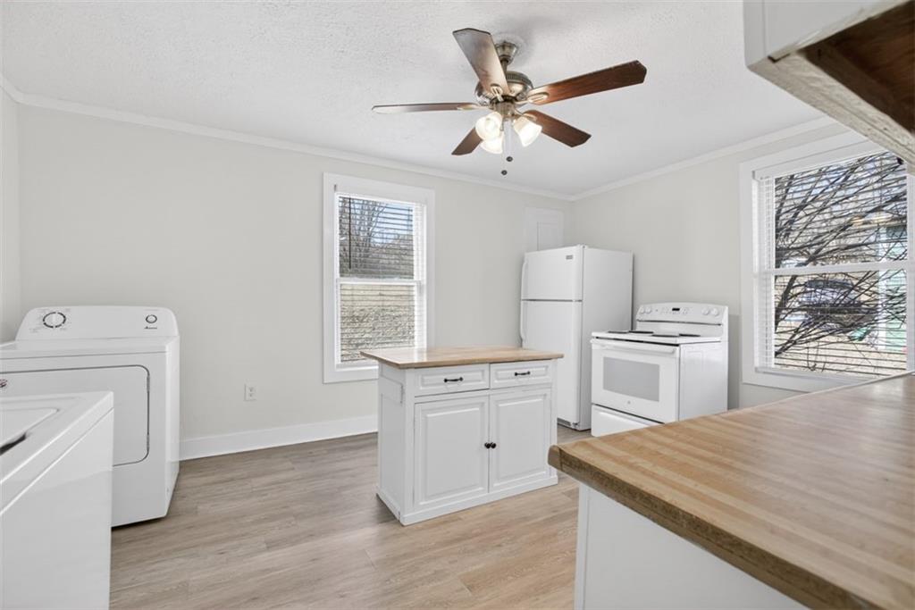 246 Spring Street Commerce, GA 30529 - Photo 7 of 23 a kitchen with a stove cabinets and wooden floor
