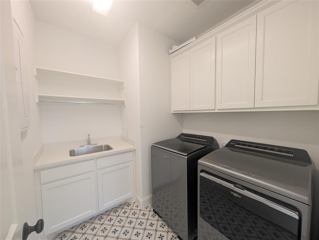15532 Fringe Tree Road Frisco, TX 75035 - Photo 14 of 31 Laundry room featuring patterned floor tiles, white shaker cabinetry, a built-in sink with a countertop, and open shelving