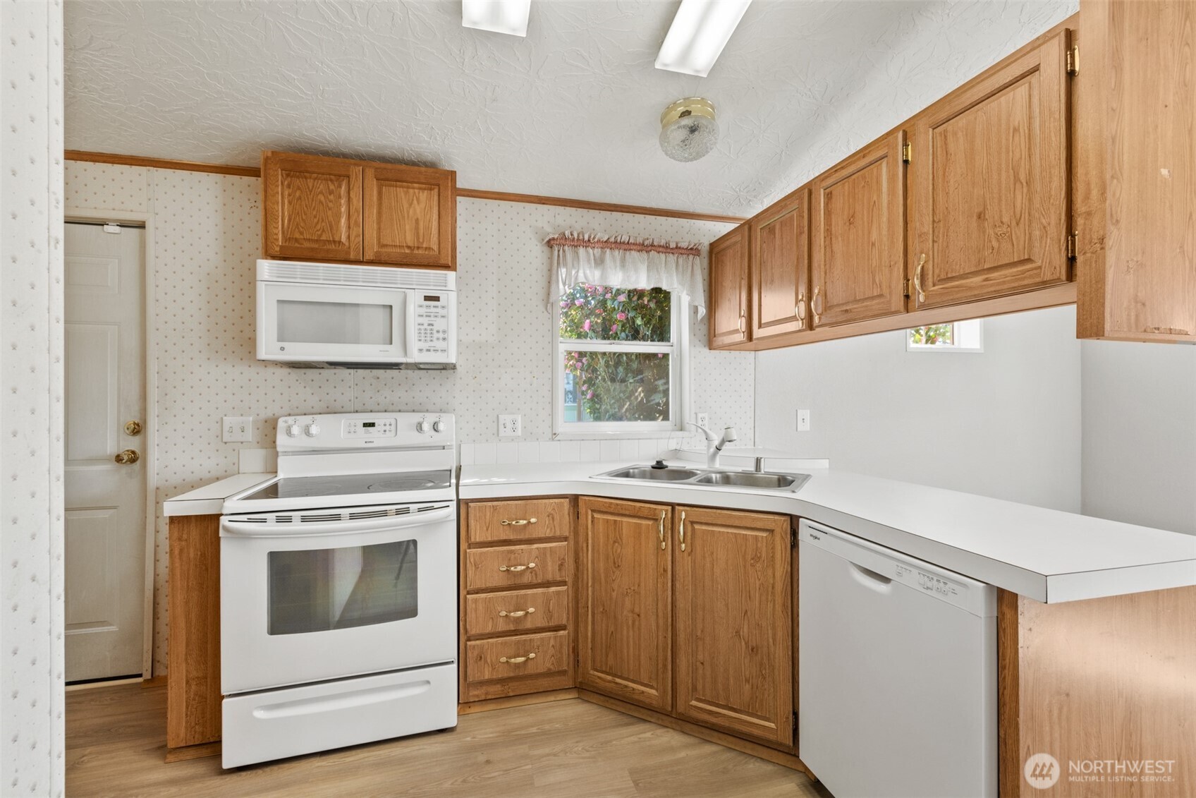 491 Mill Road, Unit 4 Sequim, WA 98382 - Photo 12 of 33 a kitchen with a stove sink and cabinets