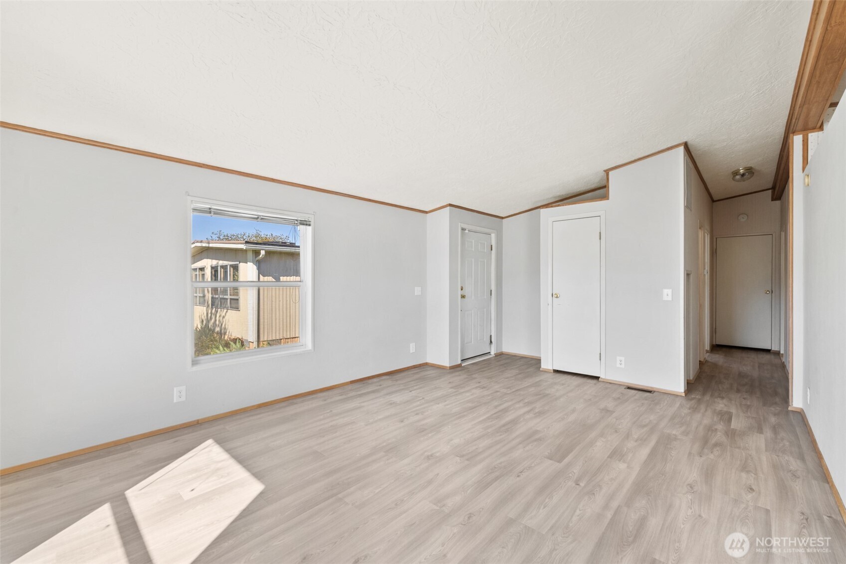 491 Mill Road, Unit 4 Sequim, WA 98382 - Photo 6 of 33 a view of an empty room with wooden floor and a window