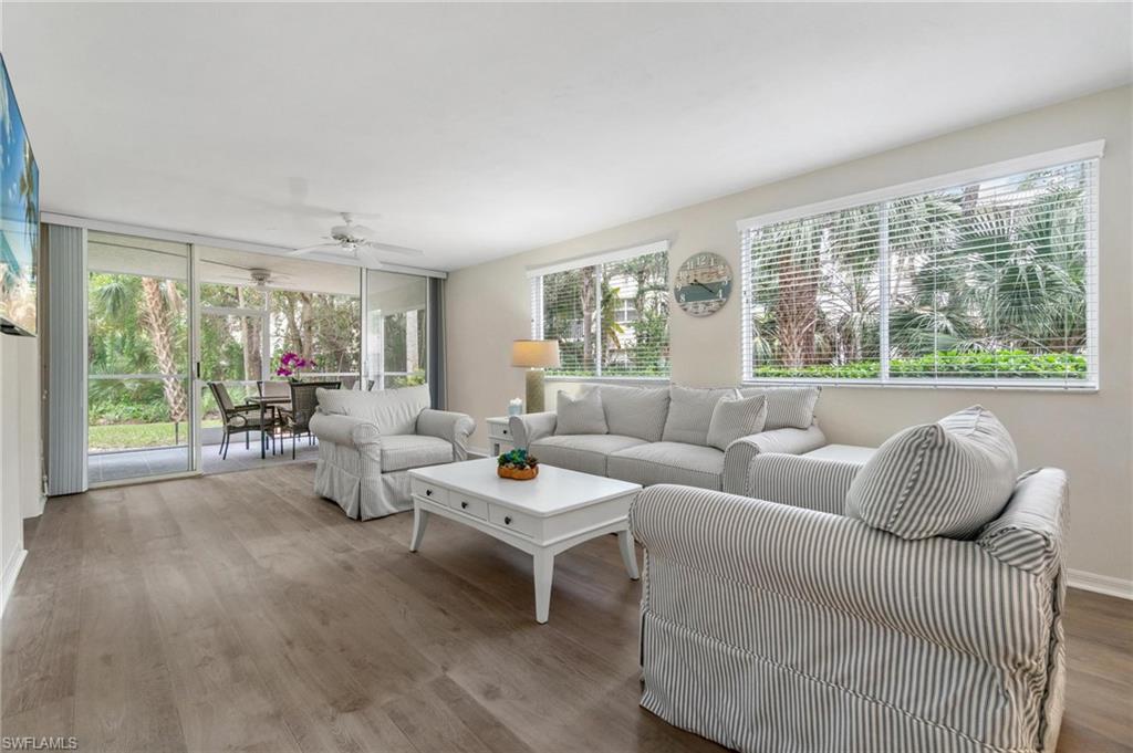 285 Naples Cove Drive, Unit 1106 Naples, FL 34110 - Photo 11 of 46 a living room with furniture and large windows