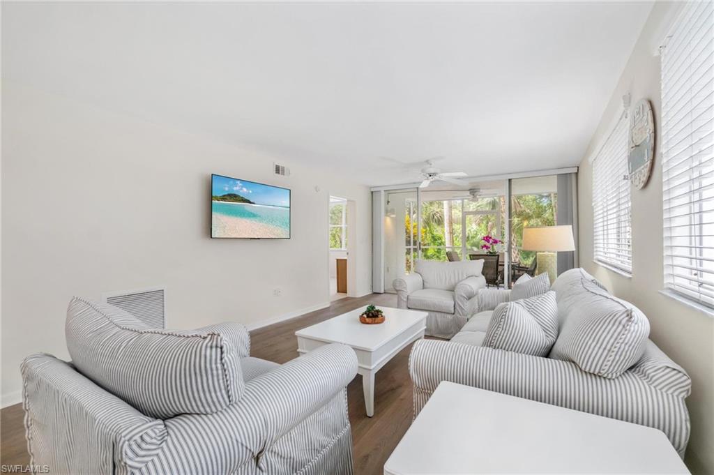 285 Naples Cove Drive, Unit 1106 Naples, FL 34110 - Photo 12 of 46 a living room with furniture and a large window