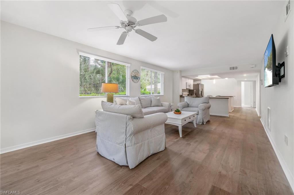 285 Naples Cove Drive, Unit 1106 Naples, FL 34110 - Photo 14 of 46 a living room with furniture and a flat screen tv