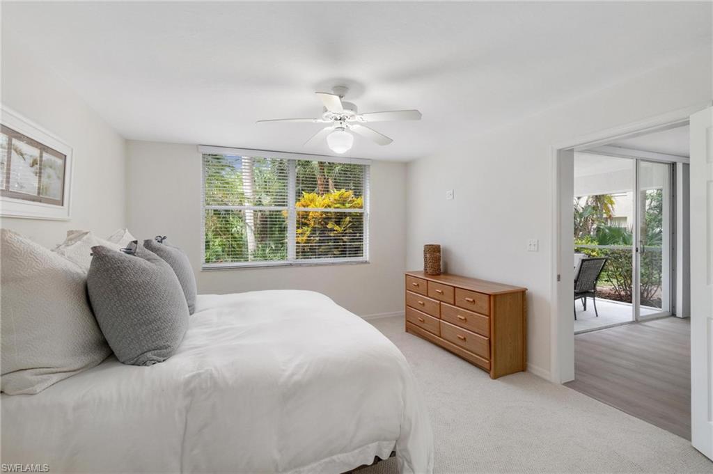 285 Naples Cove Drive, Unit 1106 Naples, FL 34110 - Photo 19 of 46 a bedroom with a bed and a chandelier