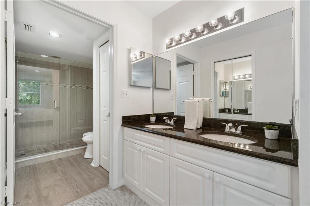 285 Naples Cove Drive, Unit 1106 Naples, FL 34110 - Photo 22 of 46 a bathroom with a granite countertop sink a toilet a mirror and shower