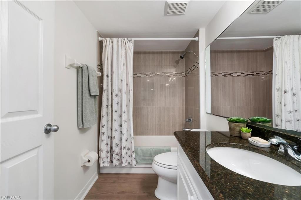285 Naples Cove Drive, Unit 1106 Naples, FL 34110 - Photo 27 of 46 a bathroom with a granite countertop sink toilet a shower and a mirror