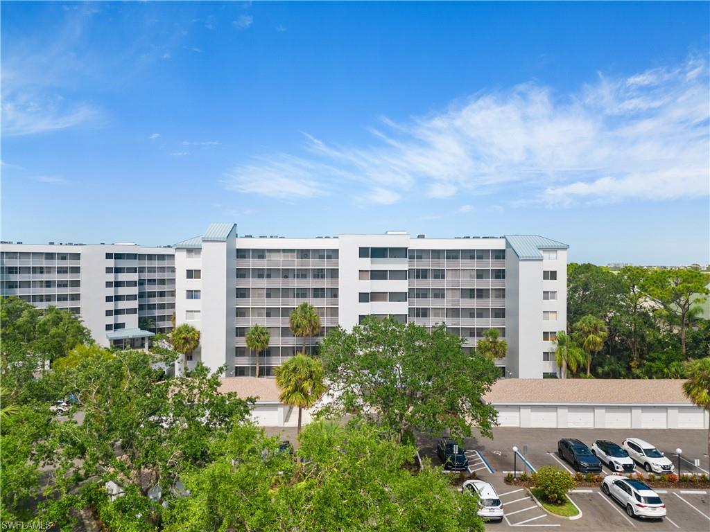 285 Naples Cove Drive, Unit 1106 Naples, FL 34110 - Photo 37 of 46 front view of a building with a yard