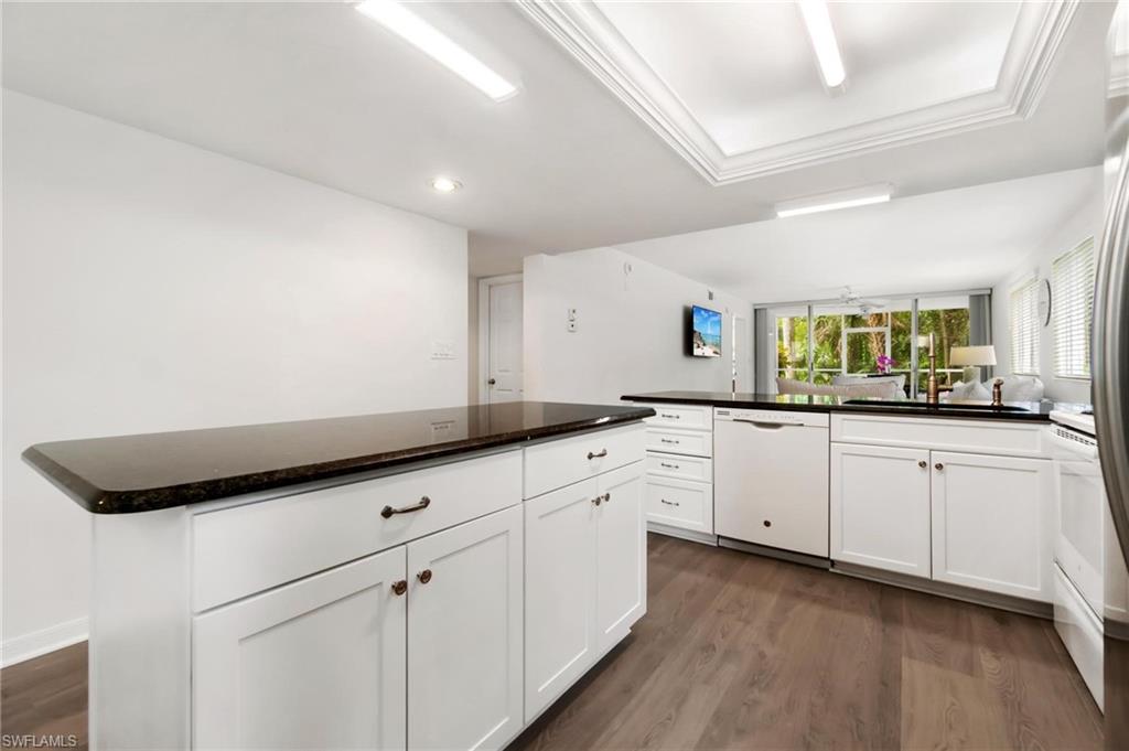 285 Naples Cove Drive, Unit 1106 Naples, FL 34110 - Photo 5 of 46 a kitchen with white cabinets and sink