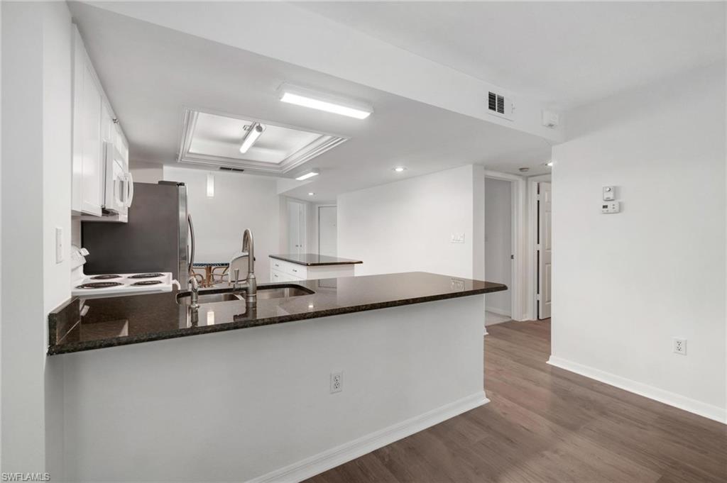 285 Naples Cove Drive, Unit 1106 Naples, FL 34110 - Photo 9 of 46 a large kitchen with a sink and a refrigerator