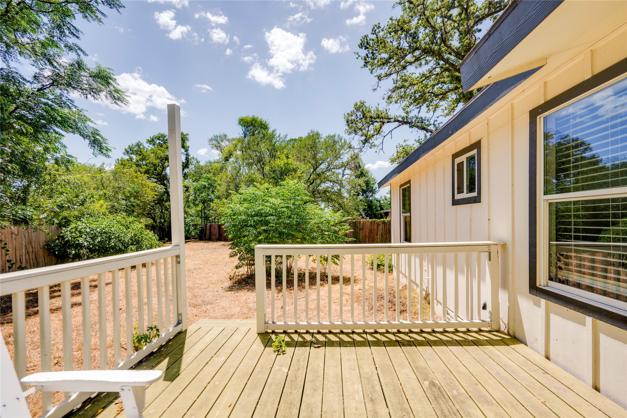 1400 Marcus Place, Unit B Austin, TX 78721 - Photo 31 of 39 A spacious wooden deck provides ample outdoor living space, leading to a private, tree-lined yard.