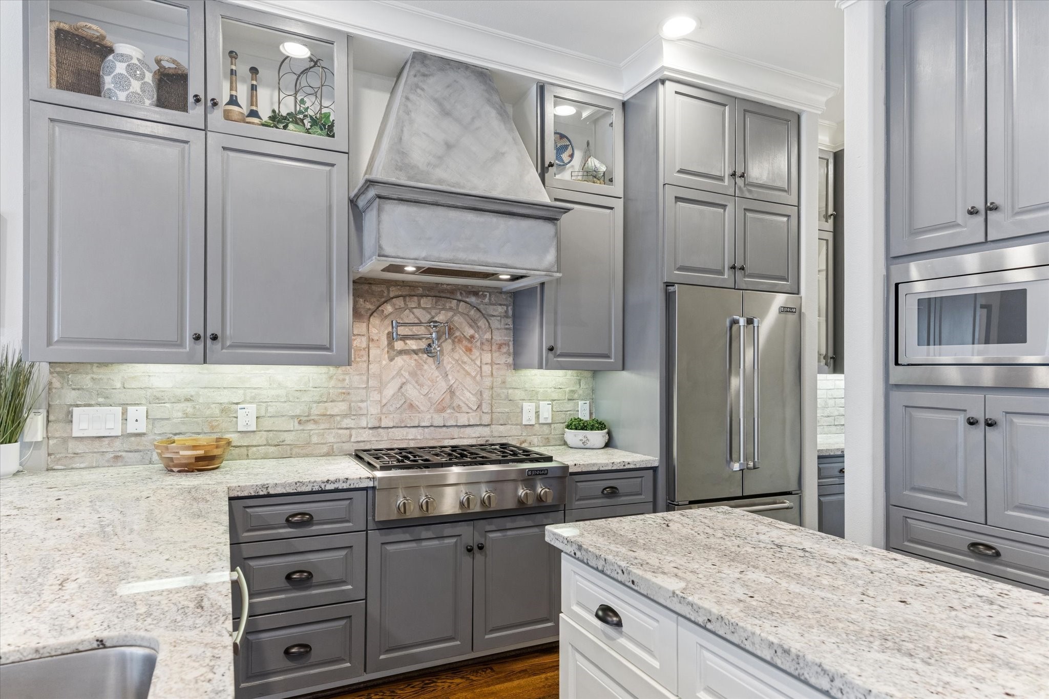 209 West 24th Street Houston, TX 77008 - Photo 10 of 36 A stylish brick backsplash and pot filler make cooking on the 6-burner gas cooktop a breeze.