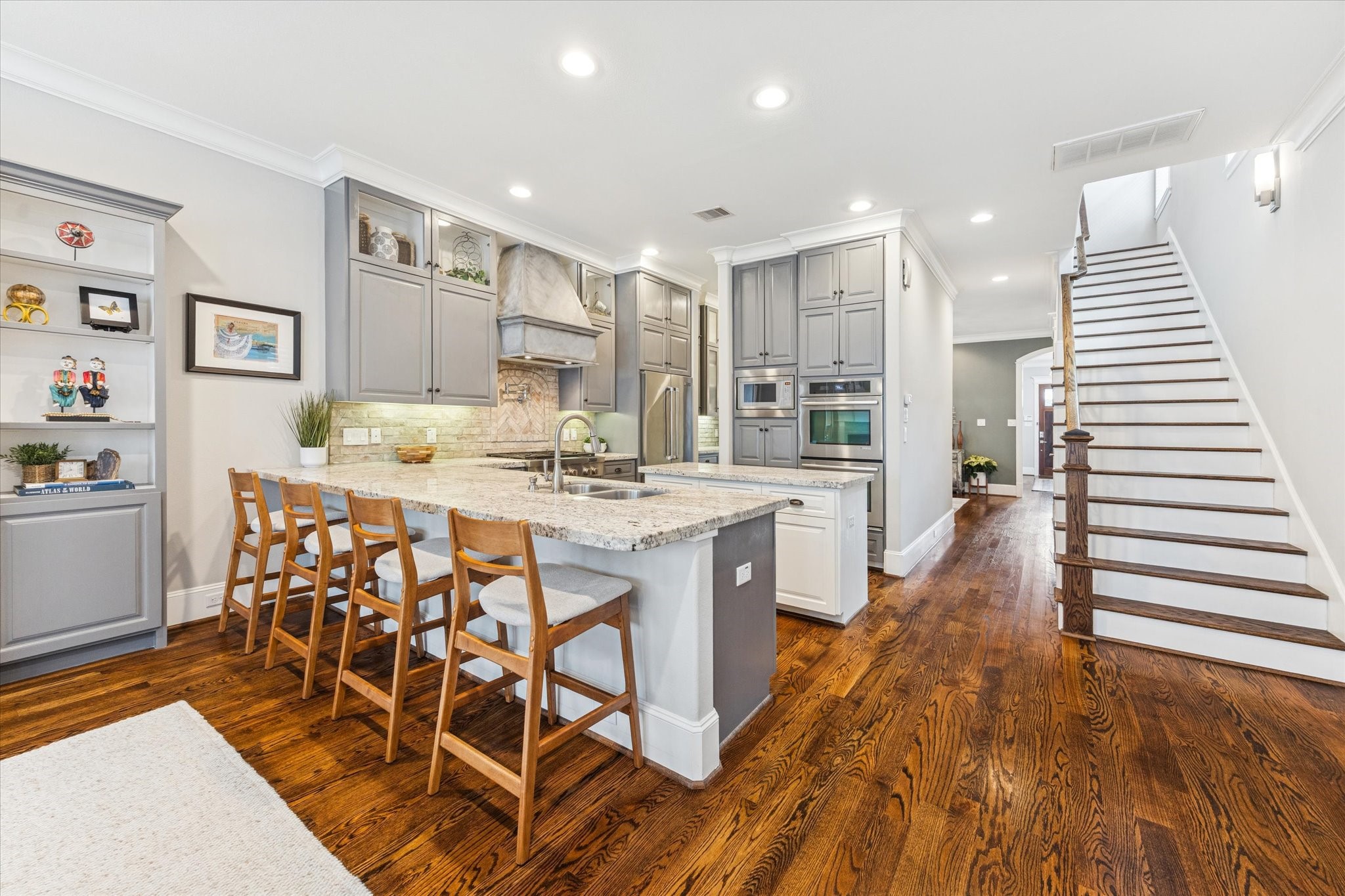 209 West 24th Street Houston, TX 77008 - Photo 3 of 36 The gourmet kitchen impresses with an island, breakfast bar, double ovens, butler’s pantry, pot filler, brick backsplash, 6-burner gas cooktop, and sleek stainless appliances.