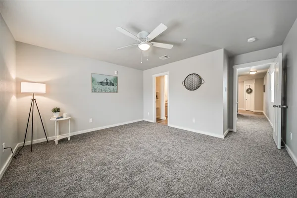 a view of an empty room with a ceiling fan and window
