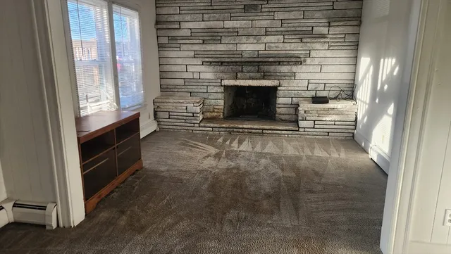 a view of empty room with a fireplace