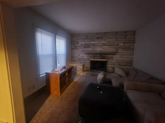 a living room with furniture and a air conditioner vent