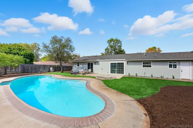 a view of a house with swimming pool and sitting area
