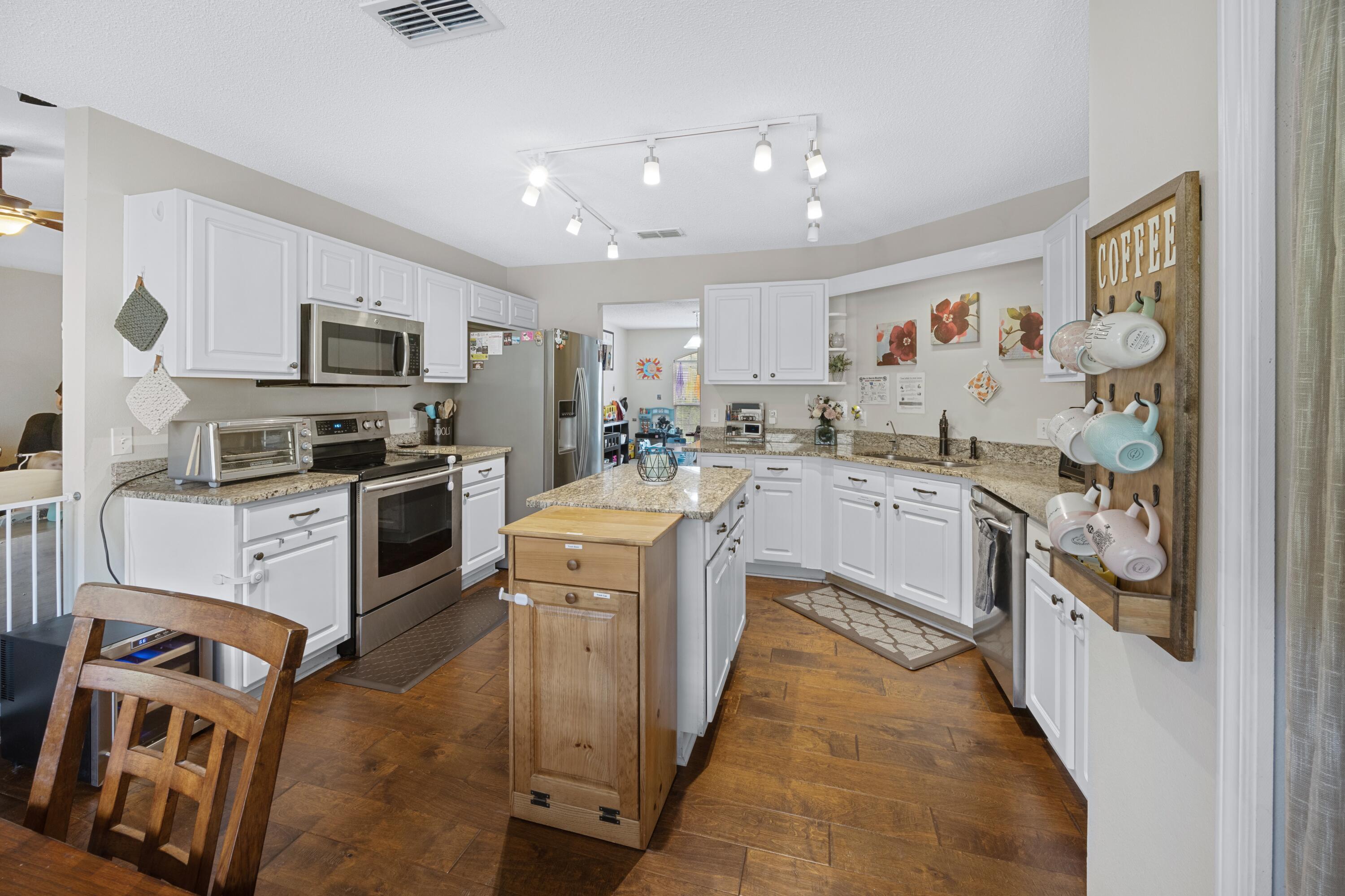 419 Bobby Drive Crestview, FL 32536 - Photo 13 of 42 a kitchen with stainless steel appliances granite countertop a stove top oven a sink and a refrigerator