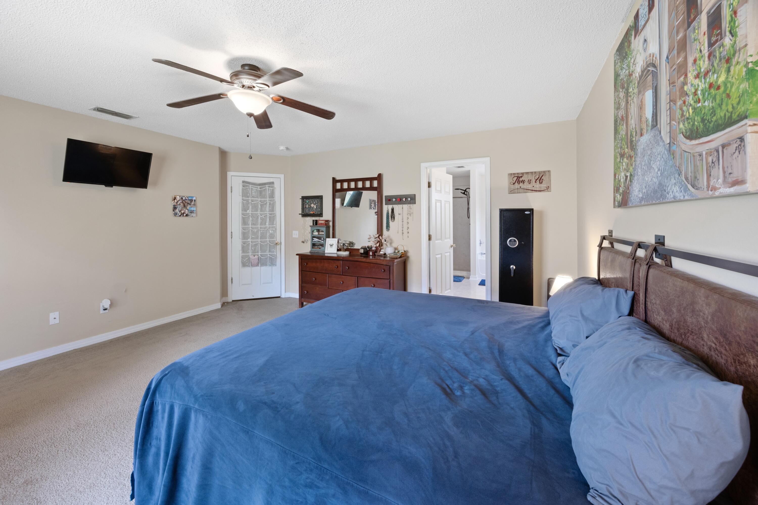 419 Bobby Drive Crestview, FL 32536 - Photo 17 of 42 a spacious bedroom with a bed and a flat screen tv