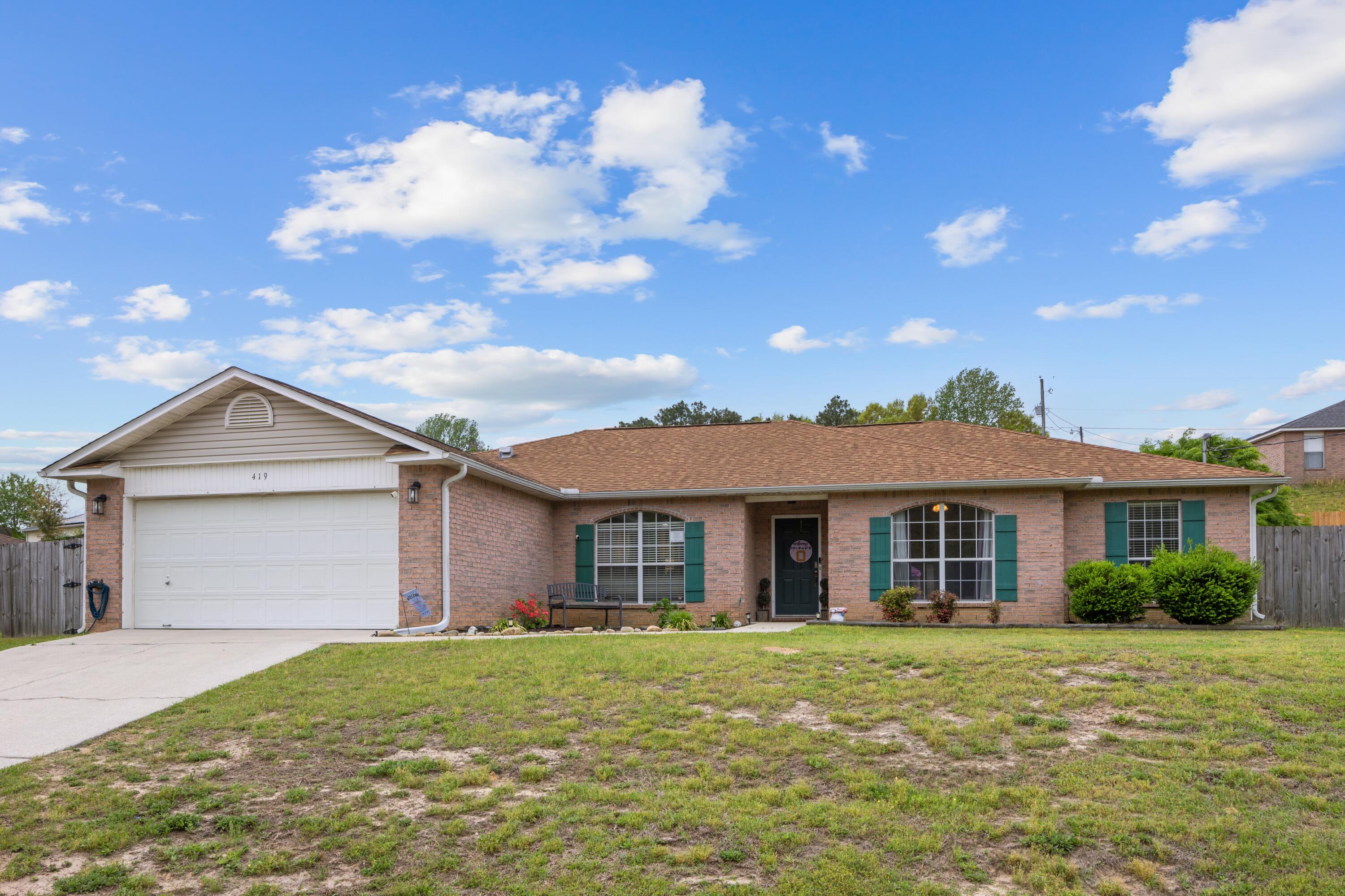 419 Bobby Drive Crestview, FL 32536 - Photo 2 of 42 a front view of a house with a garden and yard