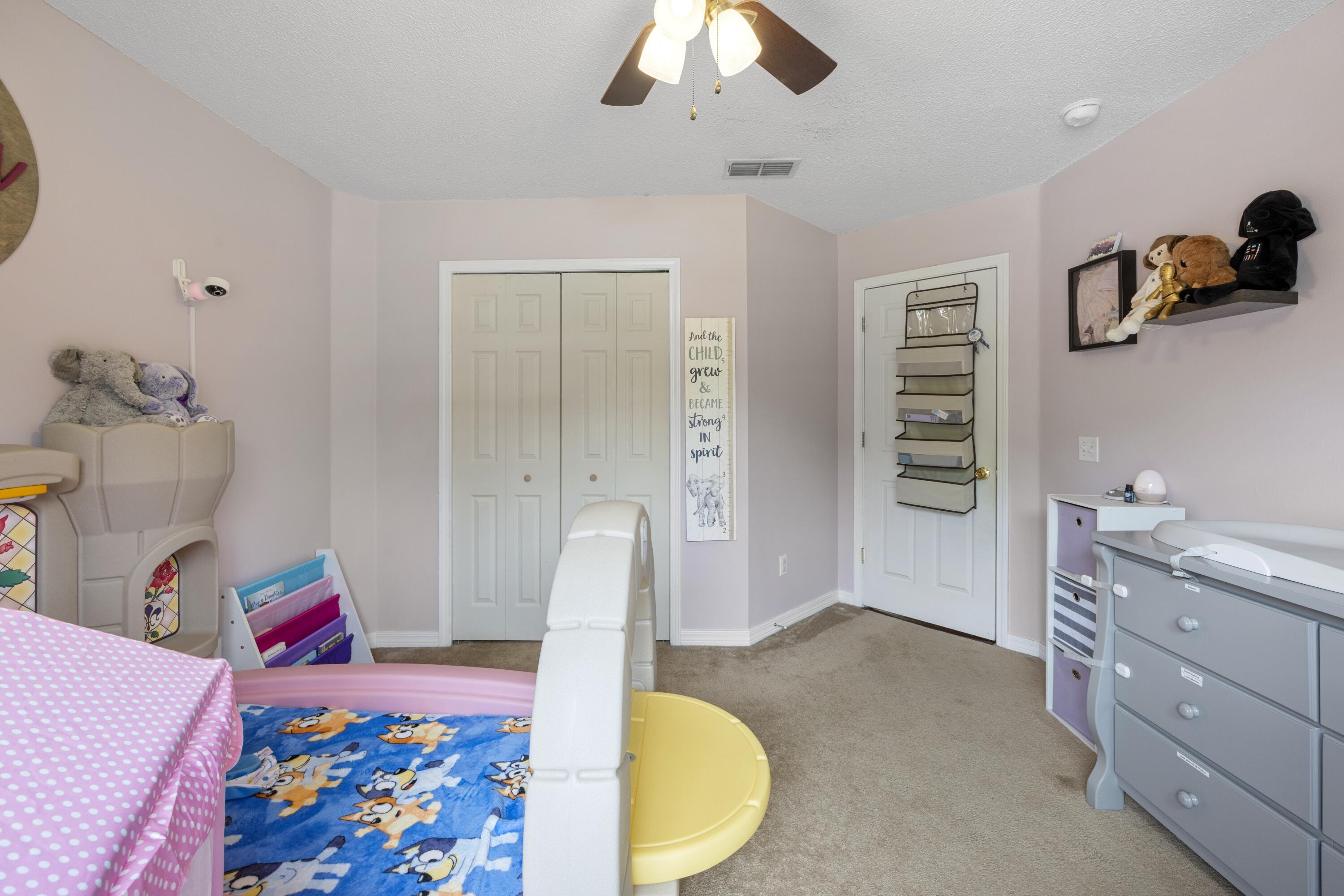 419 Bobby Drive Crestview, FL 32536 - Photo 25 of 42 a bed room with a bed and a chandelier