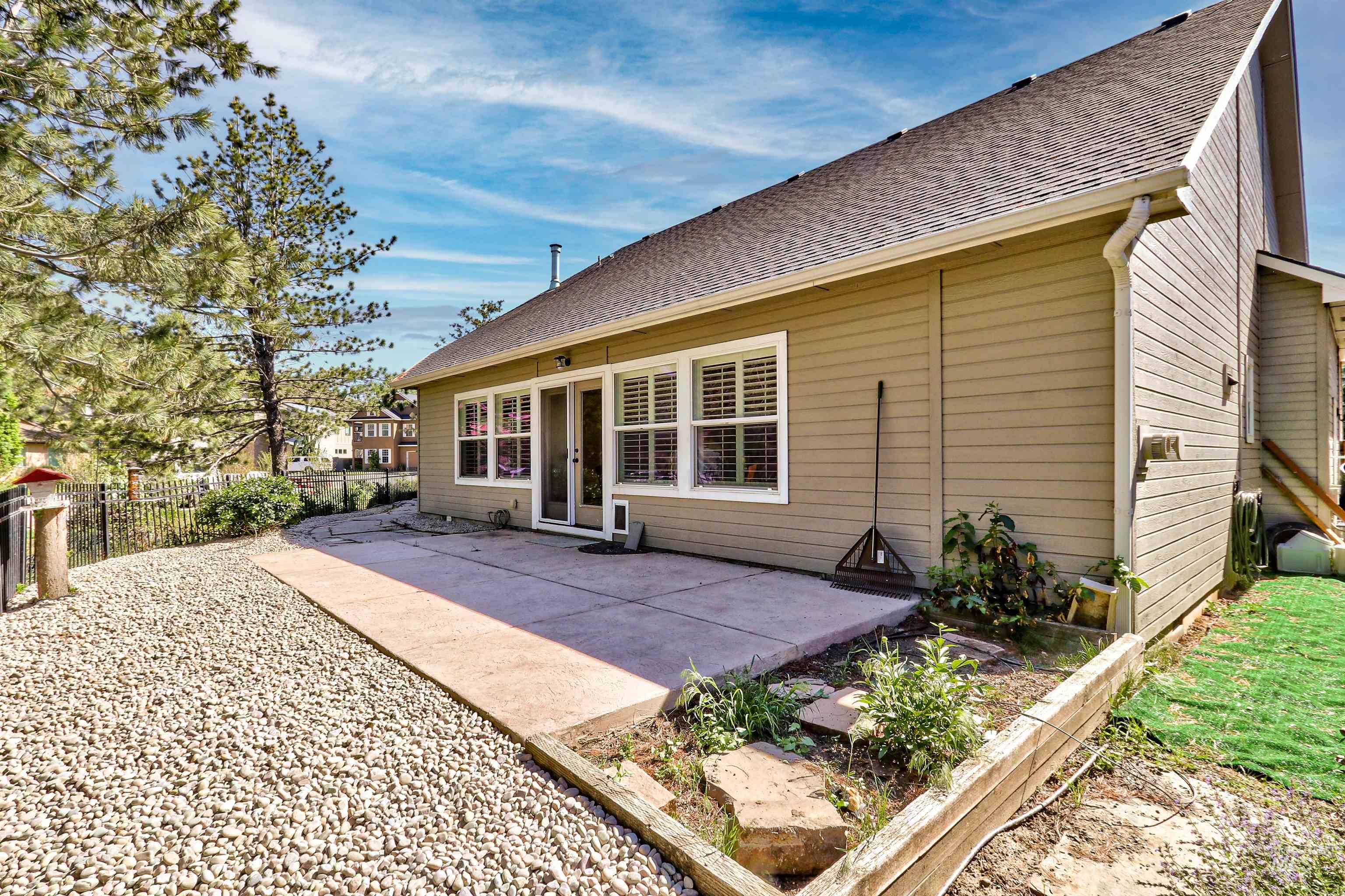 892 South Capitola Way Boise, ID 83712 - Photo 33 of 34 Rear exterior featuring a concrete patio, sliding glass door entry, and multiple windows with interior plantation shutters