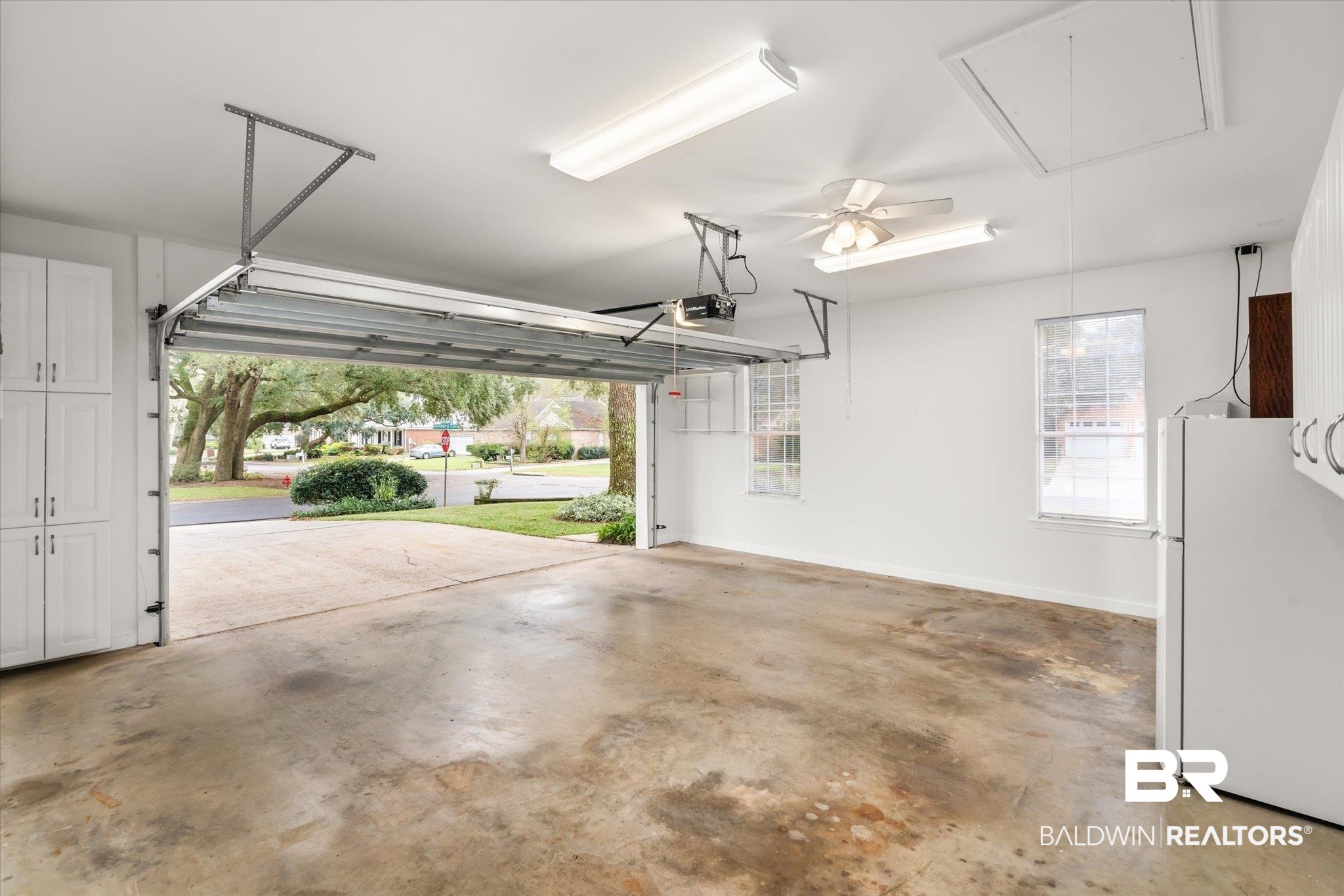 19924 Hunters Loop Fairhope, AL 36532 - Photo 27 of 40 Garage featuring white refrigerator, a garage door opener, and ceiling fan