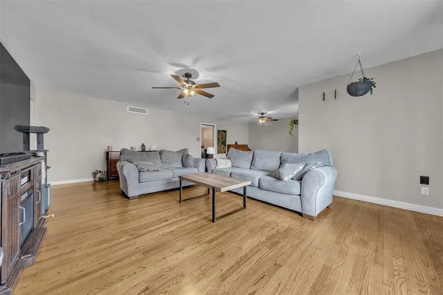 a living room with furniture and a wooden floor