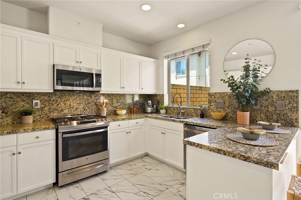 6807 Simmons Way Moorpark, CA 93021 - Photo 5 of 43 a kitchen with granite countertop a sink stove and microwave
