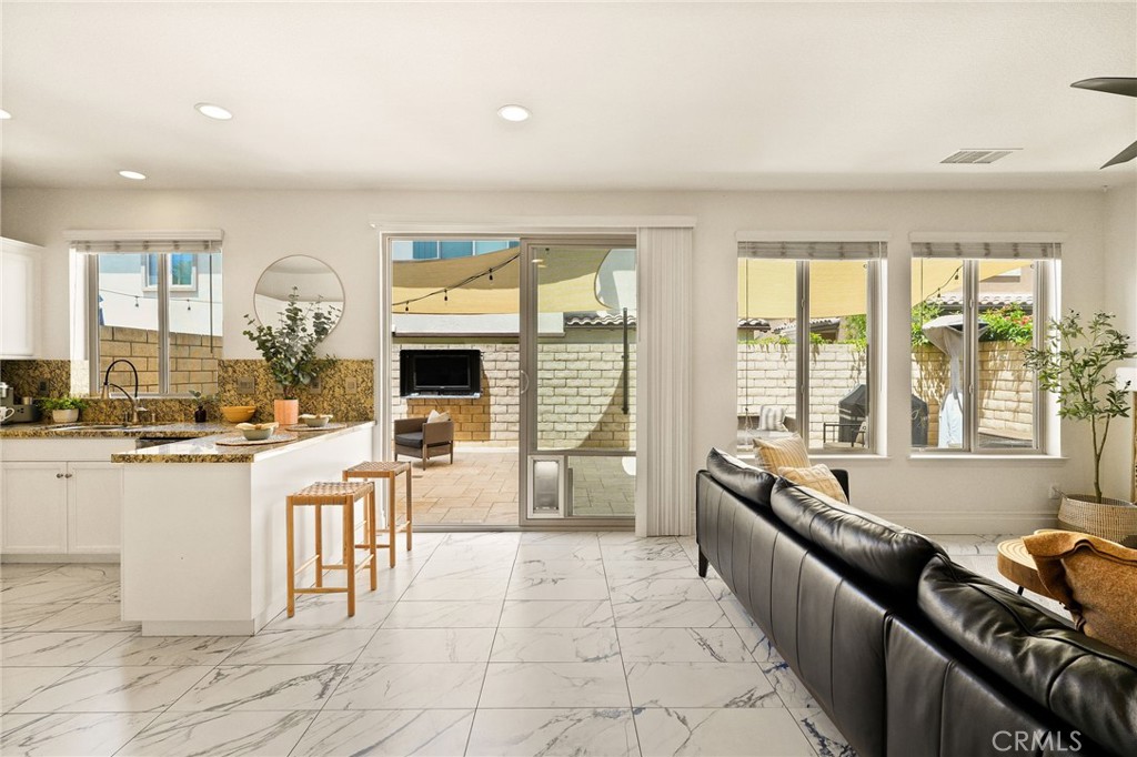 6807 Simmons Way Moorpark, CA 93021 - Photo 9 of 43 a large living room with stainless steel appliances granite countertop a large window and a couch