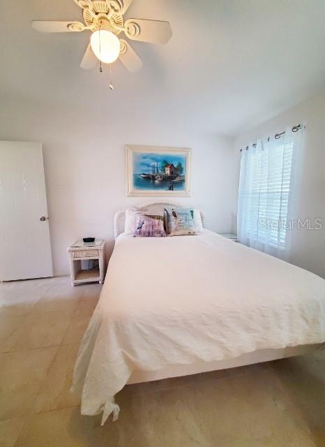 29200 South Jones Loop Road, Unit 125 Punta Gorda, FL 33950 - Photo 22 of 52 a bedroom with a bed and a chandelier