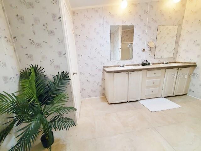 29200 South Jones Loop Road, Unit 125 Punta Gorda, FL 33950 - Photo 29 of 52 a bathroom with a granite countertop sink and a mirror
