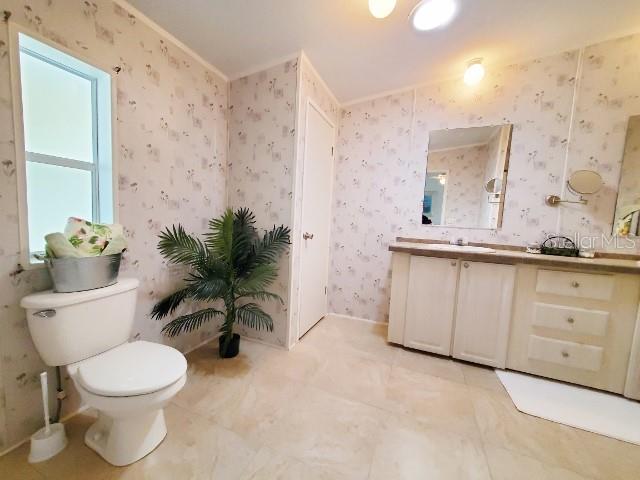 29200 South Jones Loop Road, Unit 125 Punta Gorda, FL 33950 - Photo 31 of 52 a bathroom with a granite countertop sink a toilet and a mirror