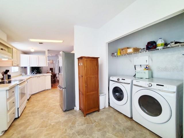 29200 South Jones Loop Road, Unit 125 Punta Gorda, FL 33950 - Photo 37 of 52 a large white kitchen with cabinets and stainless steel appliances