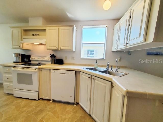 29200 South Jones Loop Road, Unit 125 Punta Gorda, FL 33950 - Photo 41 of 52 a kitchen with white cabinets sink and white appliances
