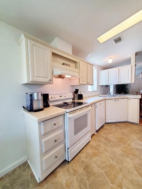 29200 South Jones Loop Road, Unit 125 Punta Gorda, FL 33950 - Photo 42 of 52 a kitchen with stainless steel appliances granite countertop a stove a sink and a refrigerator